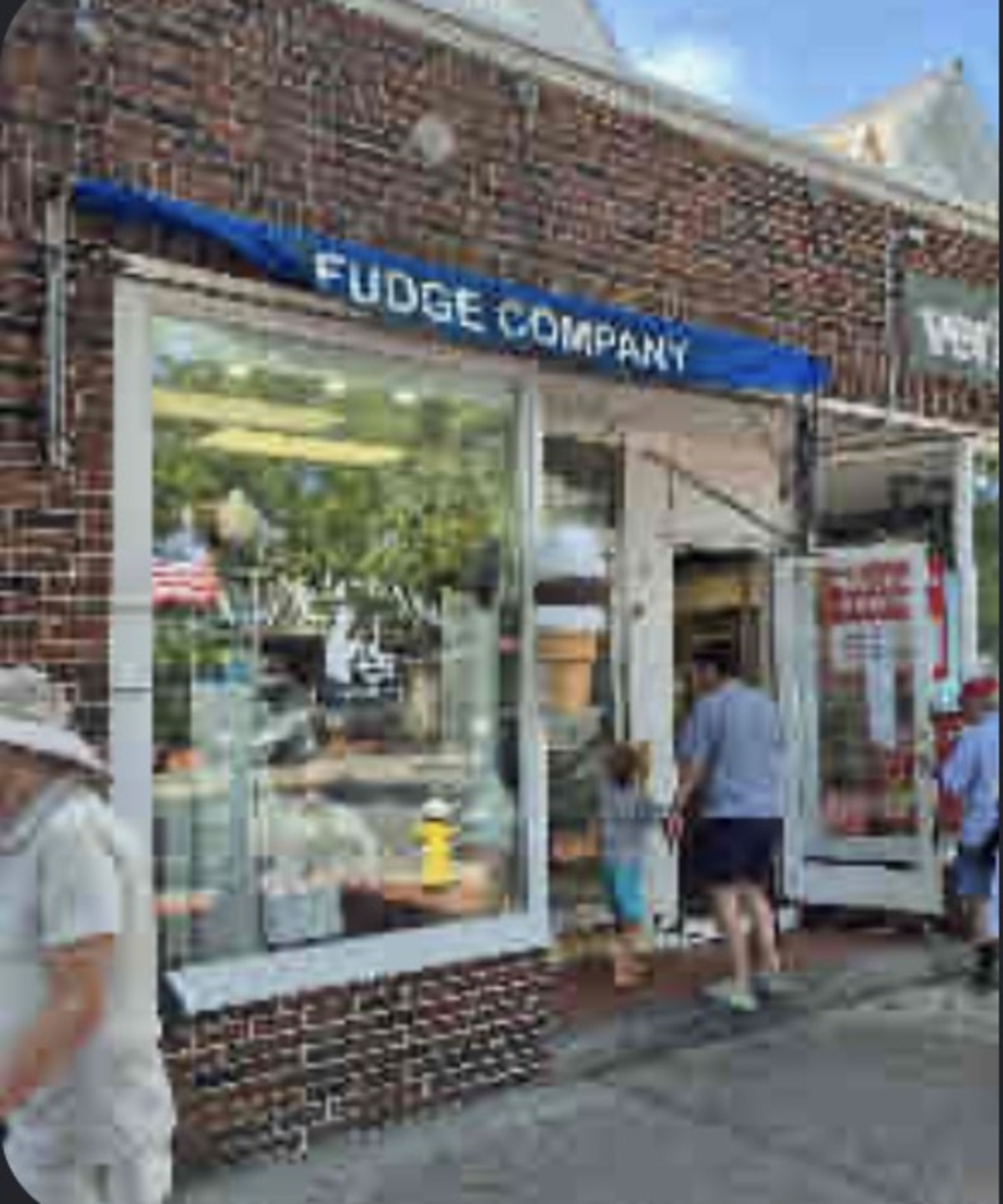The Fudge Company storefront with its blue awning and ice cream cone signs on Main Street in Southampton