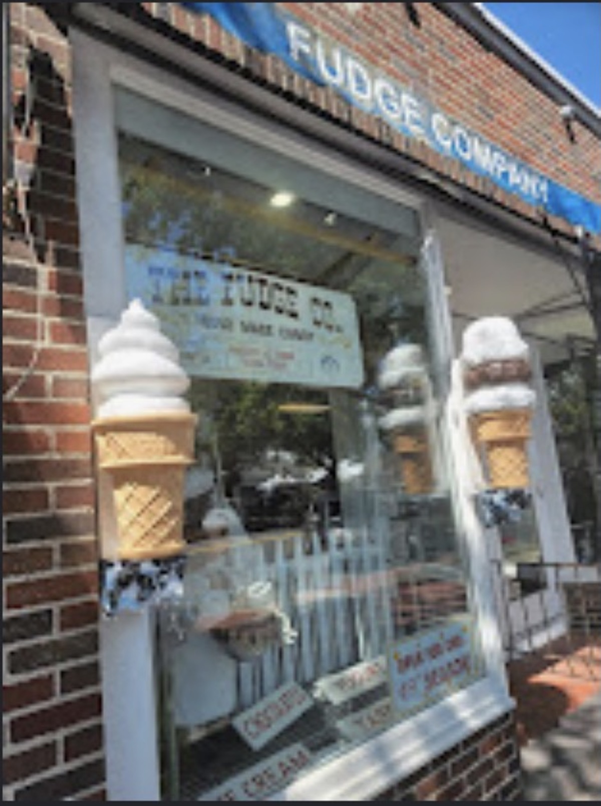 The Fudge Co window with painted ice cream cones and homemade candy sign
